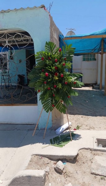 Dejan corona fúnebre y mensaje afuera de casa